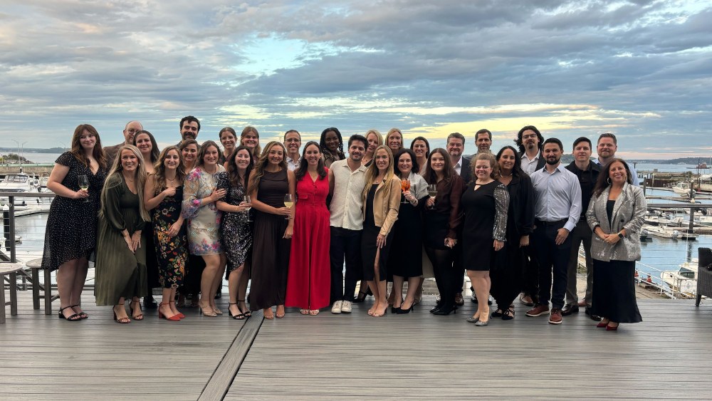 The Wheelhouse DMG team together on a waterfront deck
